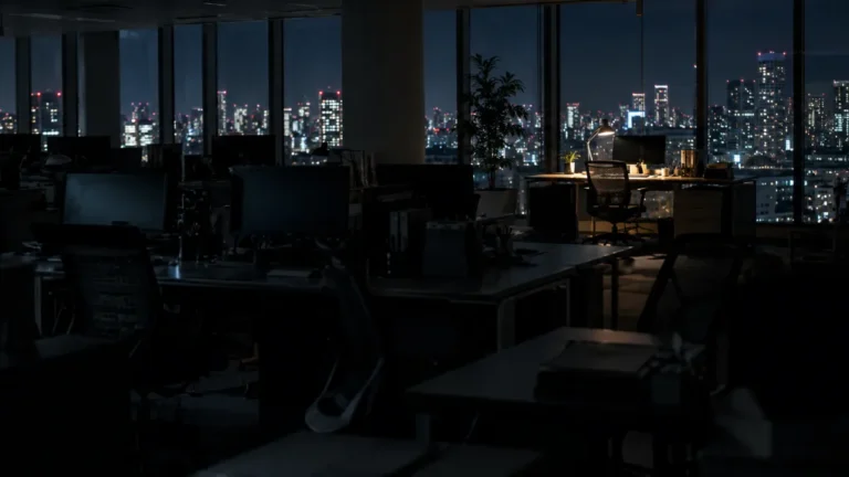 夜のオフィスで一つだけ灯りのついた席