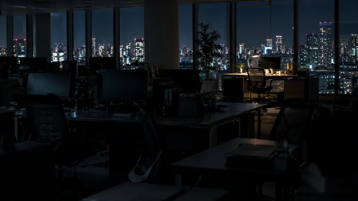 夜のオフィスで一つだけ灯りのついた席