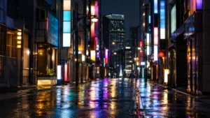深夜の繁華街の通り。雑居ビルが並び、照明が濡れた路面に反射している